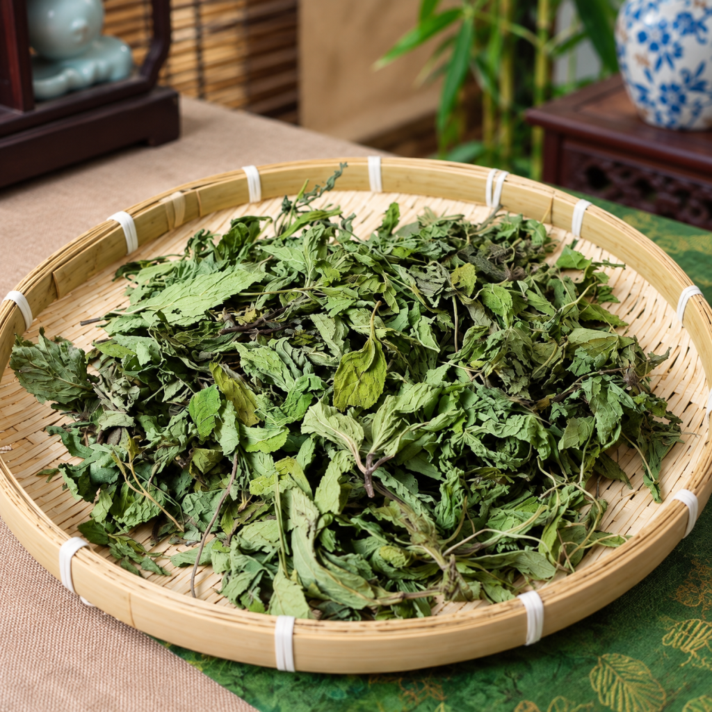 A round bamboo tray of dried green herbs and leaves on a table