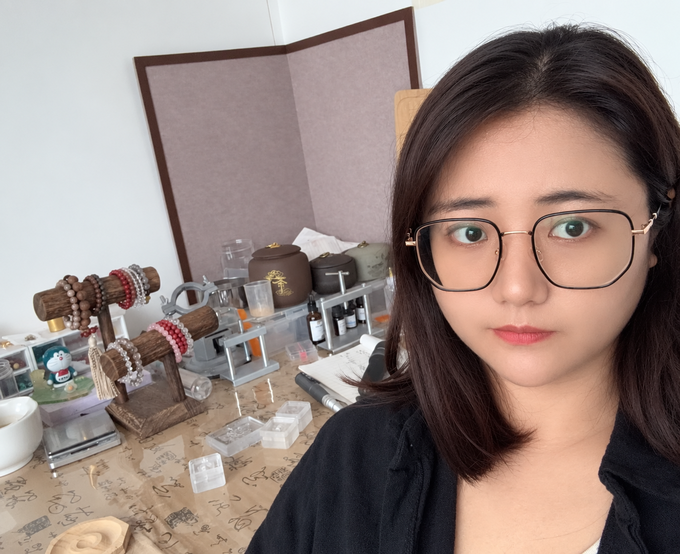 Zhang Yanan, ZendoDream production partner, at her workbench with bracelet stands, jars and tools